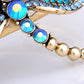 Electrifying Blue Zircon Dragonfly Over A Gold Cuff Bracelet